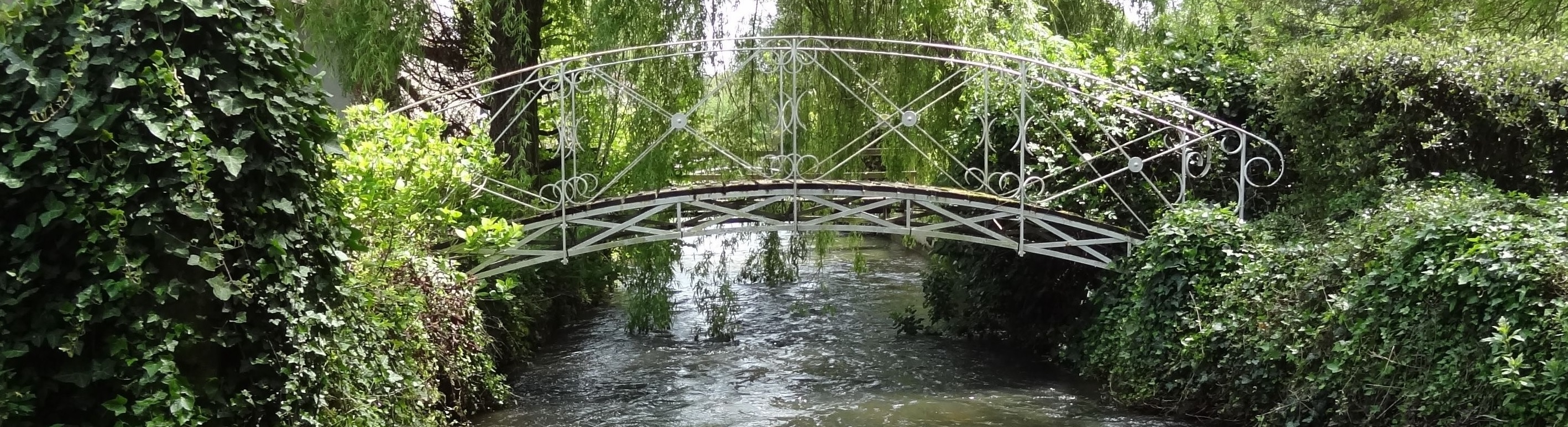 rivière claire qui passe souqs un pont en fer forgé